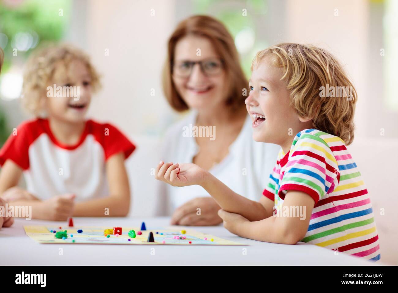 Family playing board game at home. Kids play strategic game. Little boy