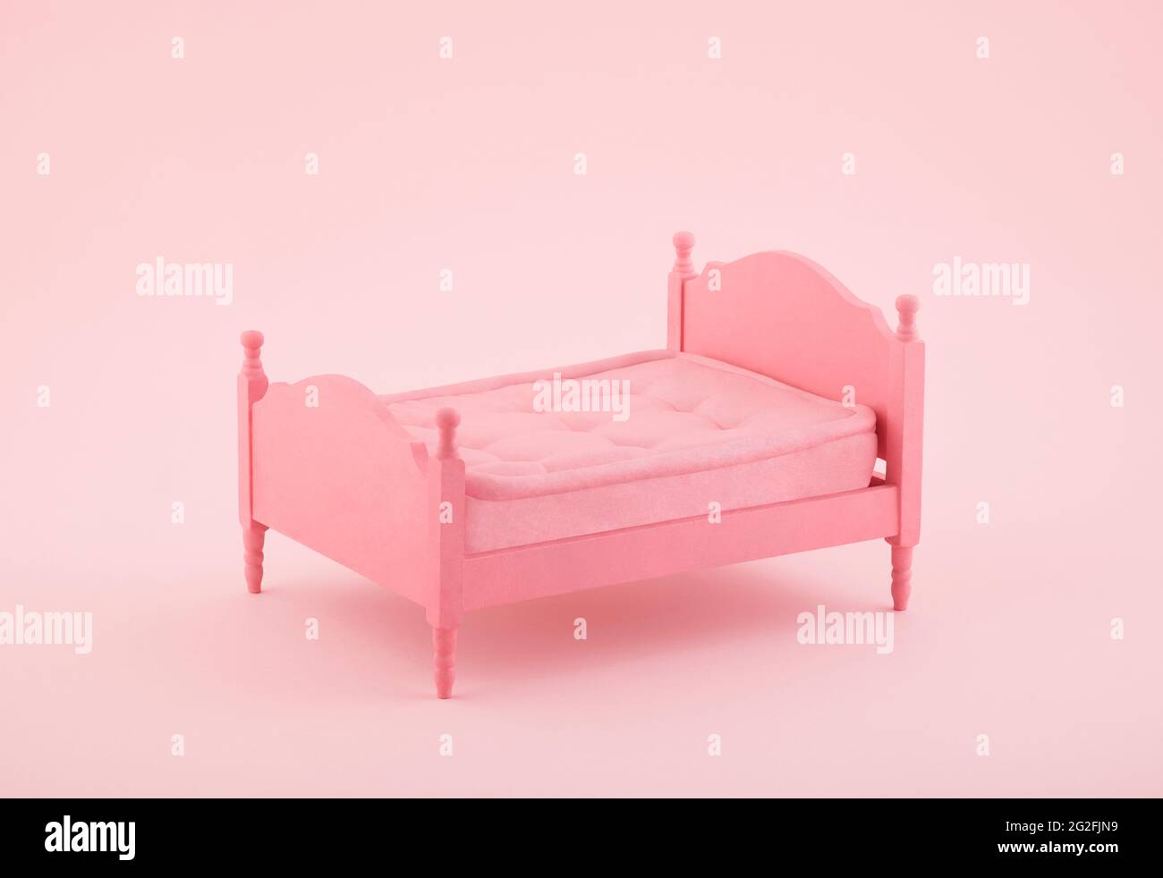 Pink wooden bed miniature on pink background Stock Photo
