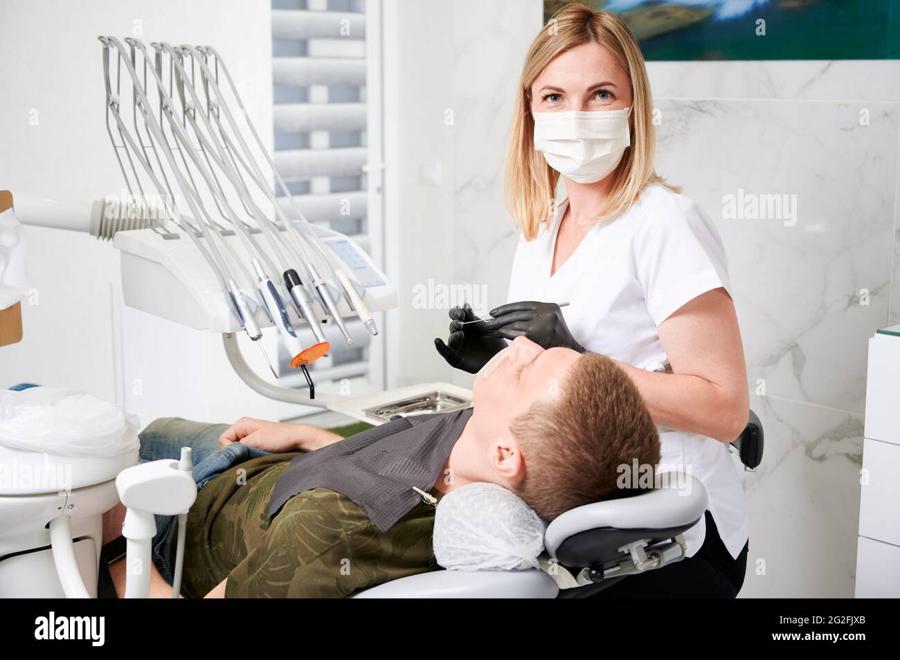 Horizontal snapshot of a pretty, young female dentist, wearing uniform