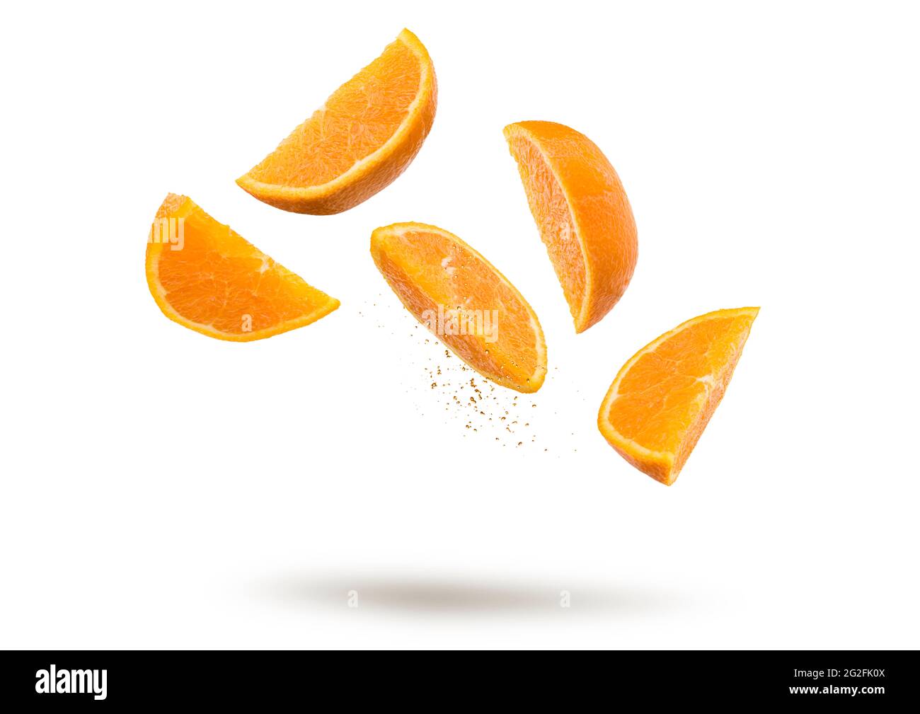 Orange fruit slices flying and dripping on white background Stock Photo