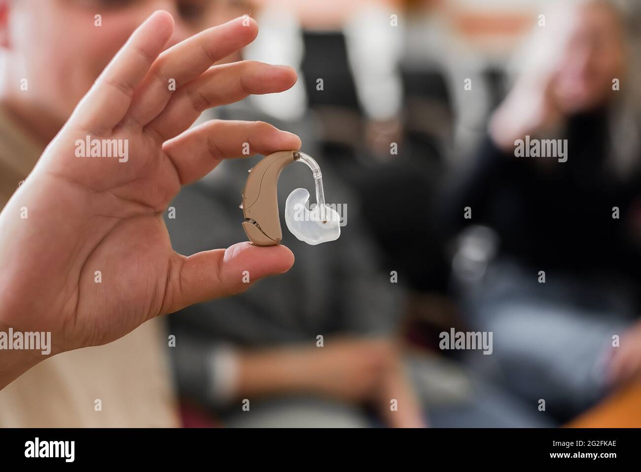 a-young-man-puts-on-a-hearing-aid-portable-sound-amplifier-for-the