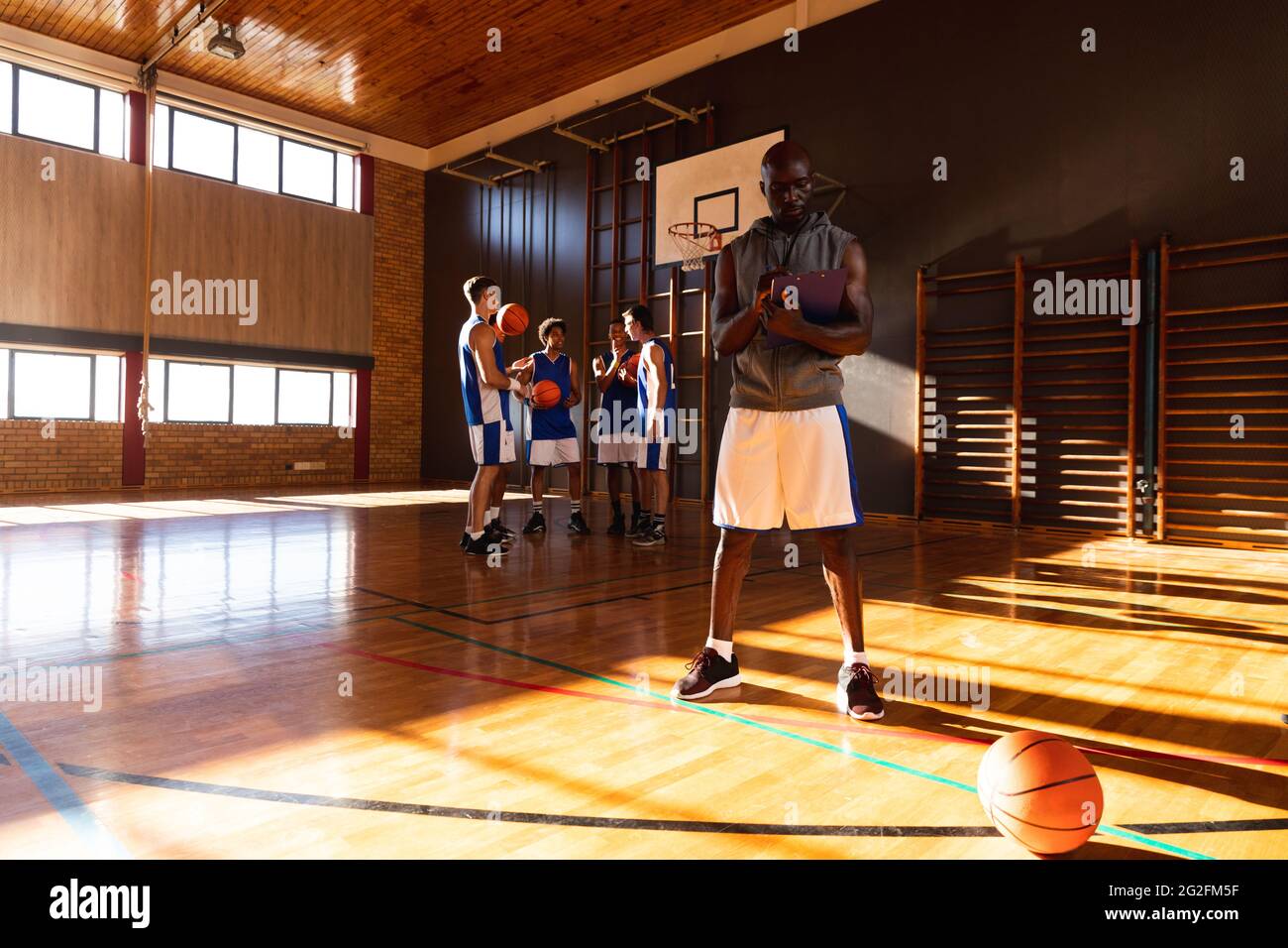 African american male basketball coach with team in background Stock