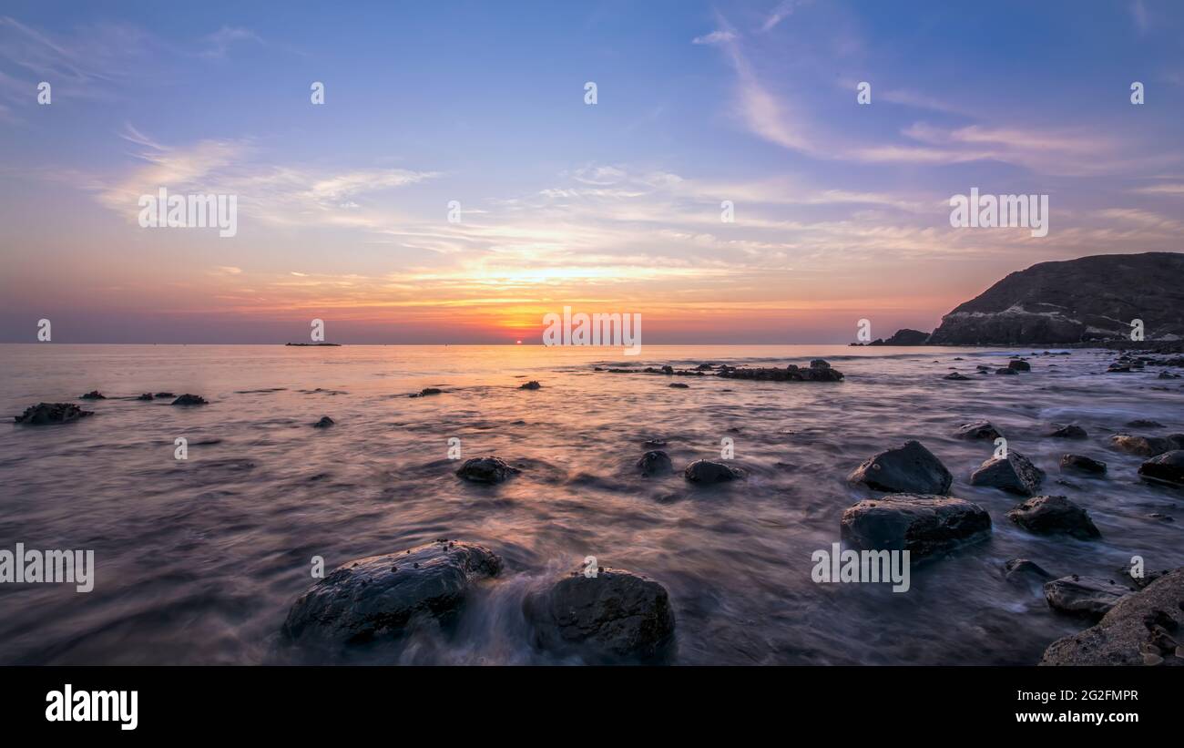 Beautiful Sunrise at Beach with Slow shutterspeed on water with sun visible. Costal Area Stock Photo