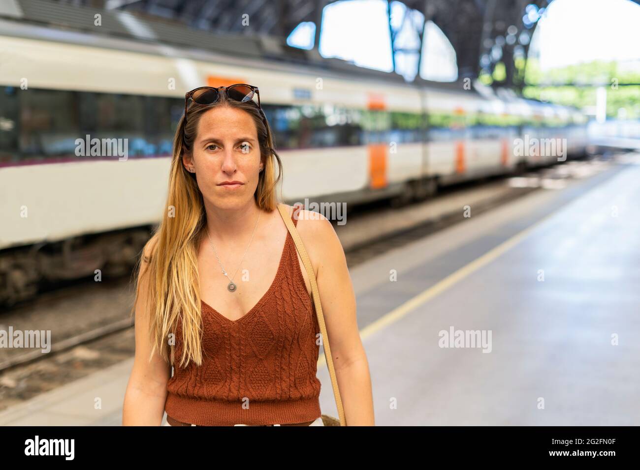Woman looking to the camera in train station waiting to the train Stock Photo
