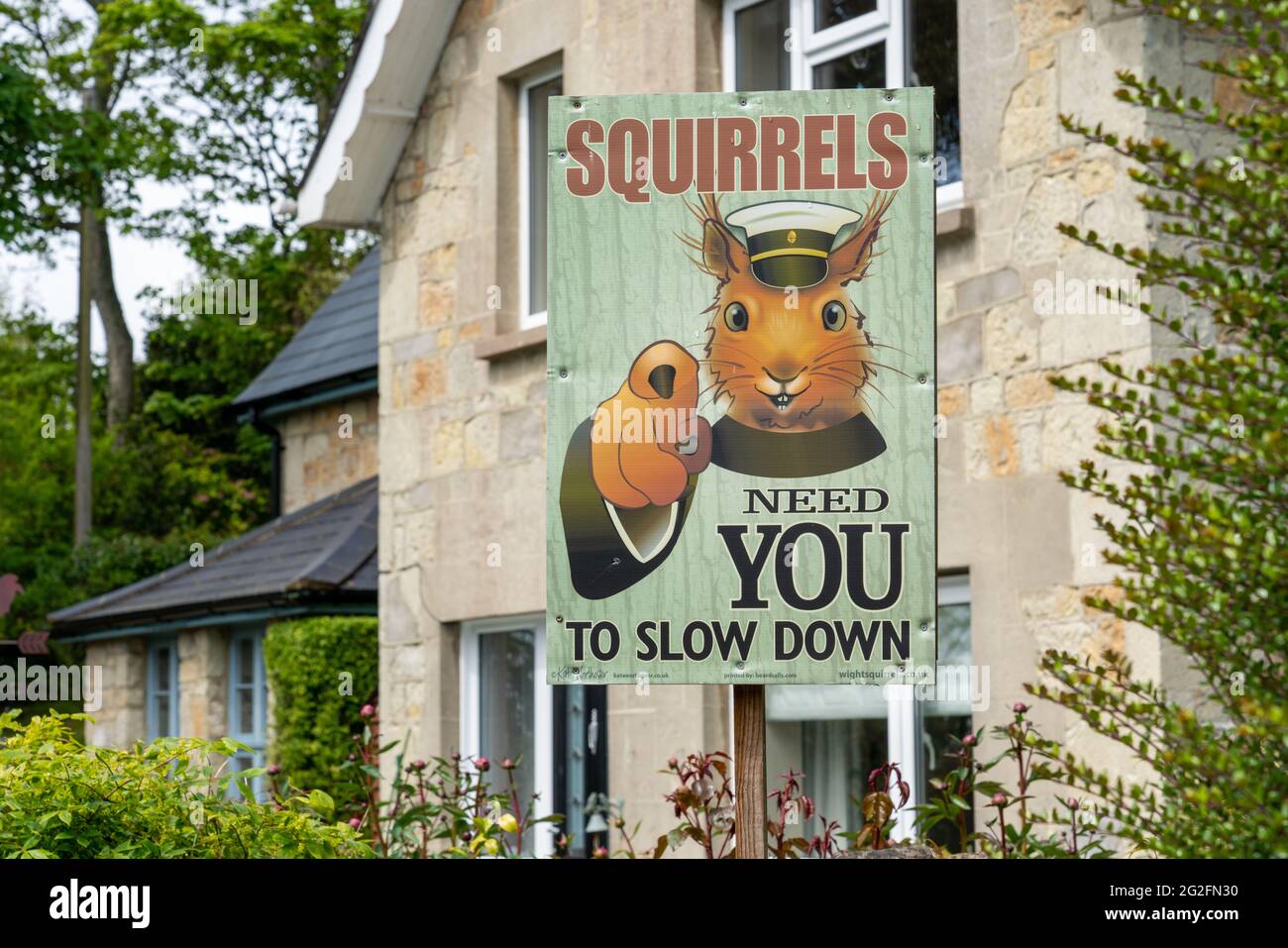 Amusing sign on the Isle of Wight in Hampshire UK with Lord Kitchener style red squirrel ordering drivers -  'Squirrels Need You To Slow Down' Stock Photo