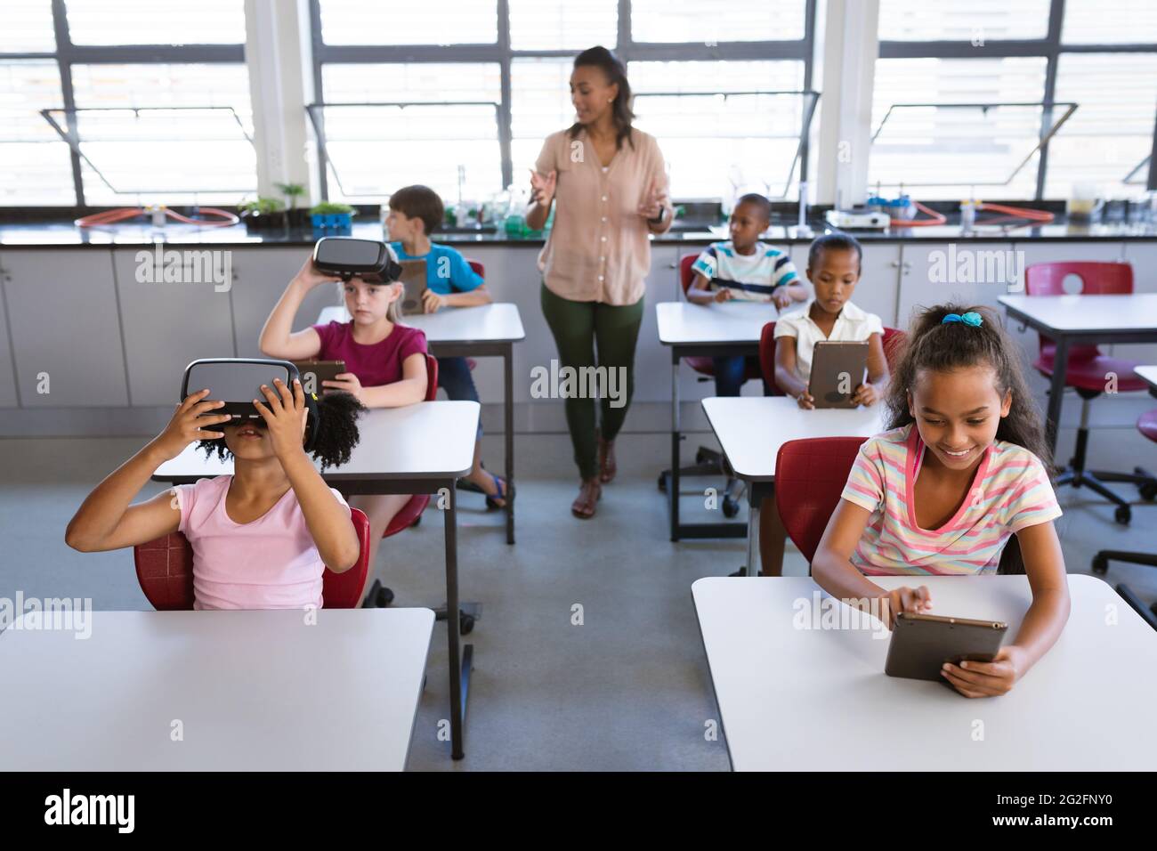African american female teacher teaching students to use electronic