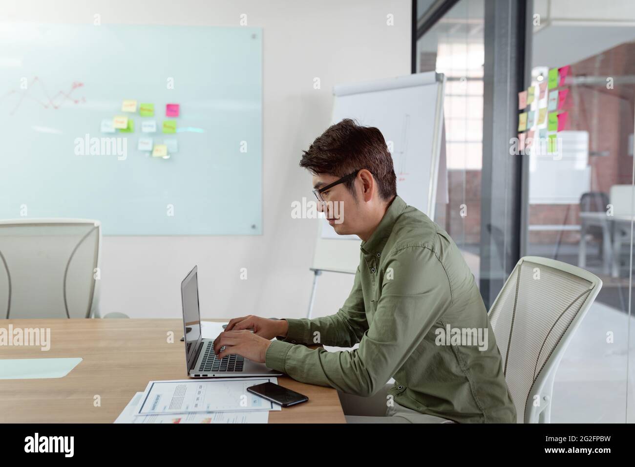Asian businessman sitting in meeting room using laptop Stock Photo