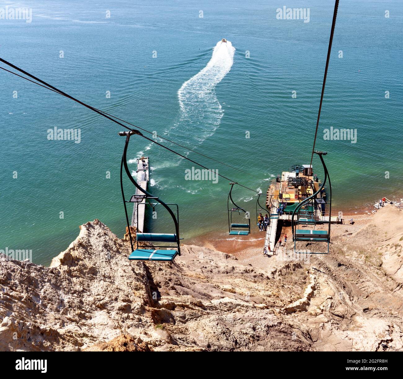 Chair lift carrying visitors up and down the steep cliffs of Alum Bay ...