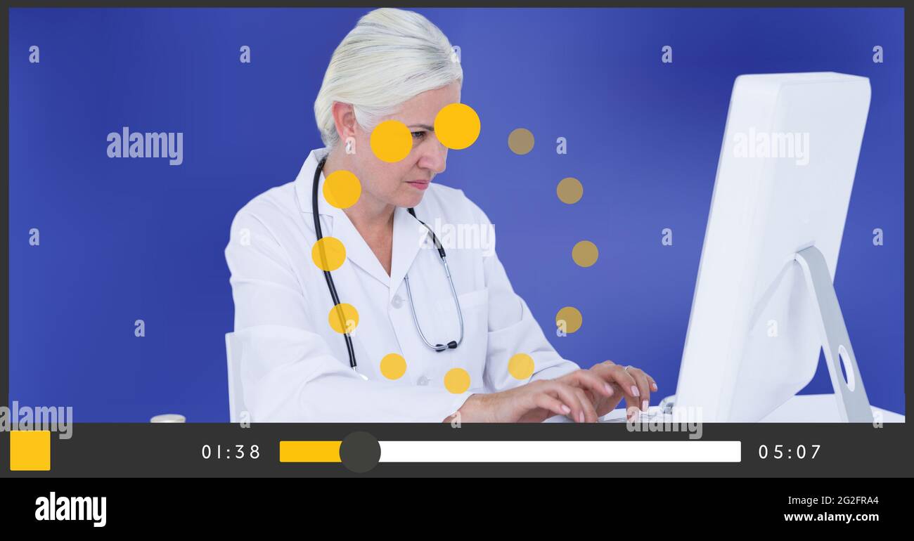 Composition of female doctor using computer on video playback interface ...