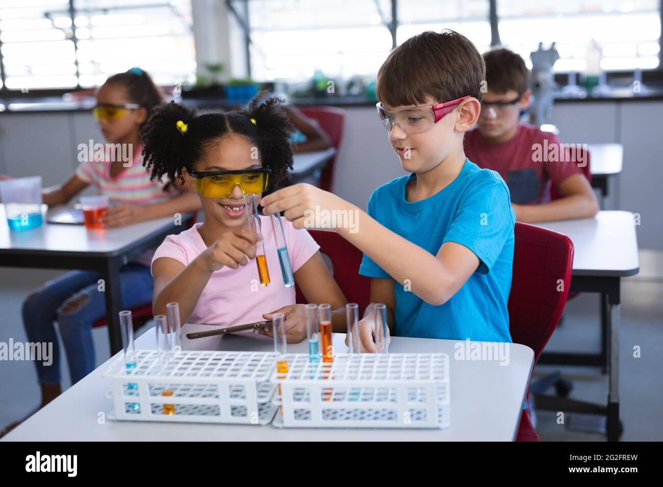 African american girl and caucasian boy holding test tubes in science ...