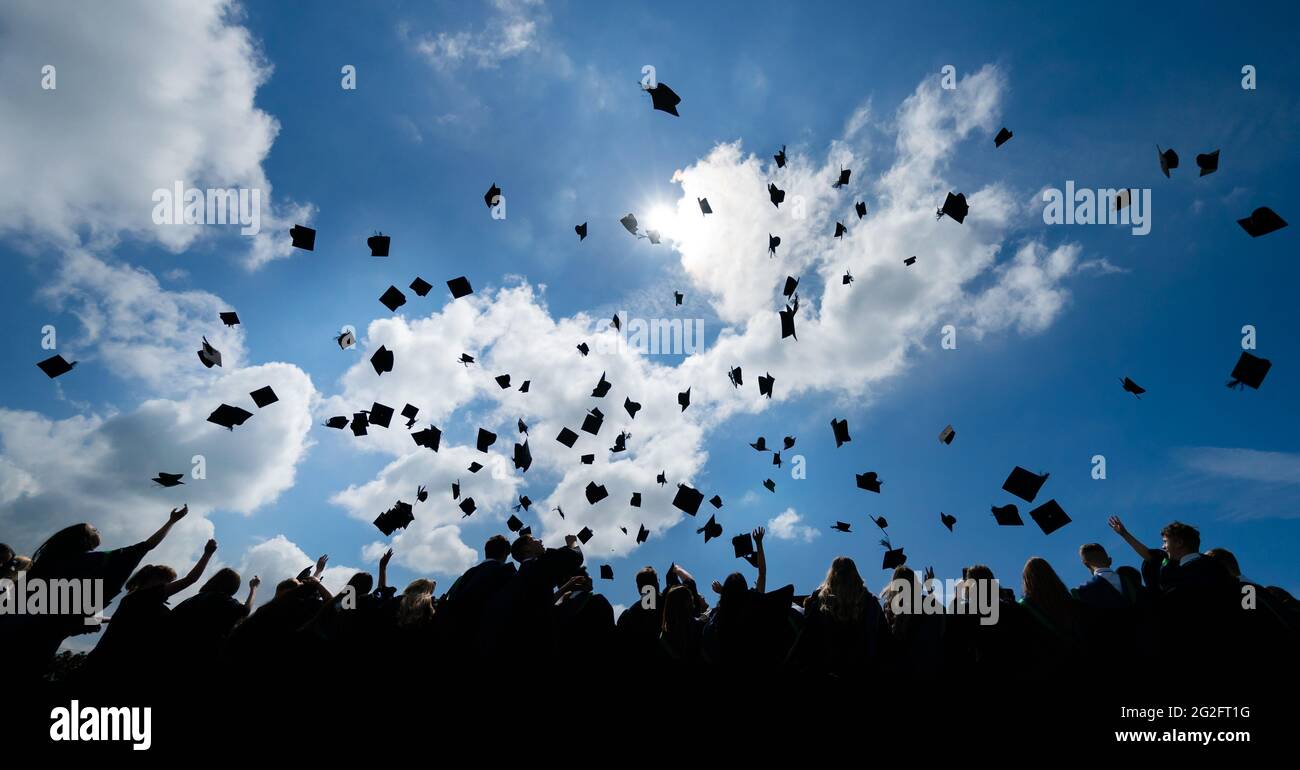 Year 11 pupils throw their mortarboards into the air following a graduation ceremony on their last day of school at BBG Academy in Bradford. Picture date: Friday June 11, 2021. Stock Photo
