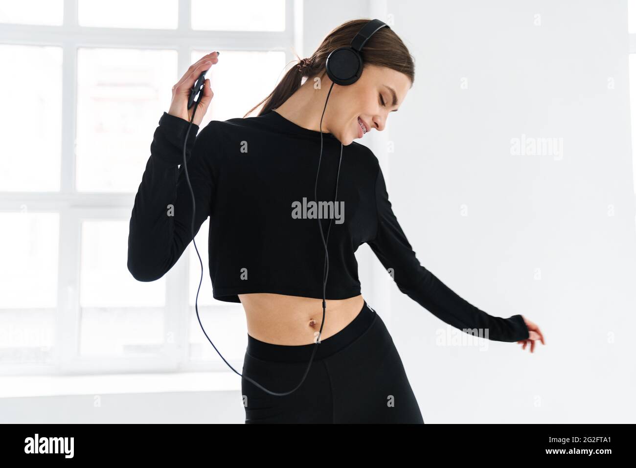 Happy woman dancing while listening music with headphones and ...