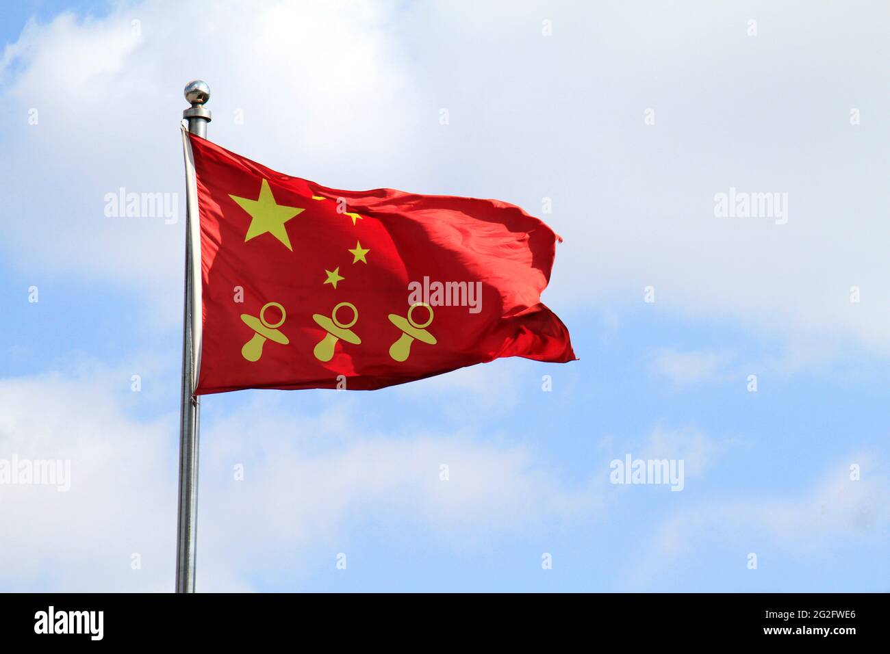 Three pacifier icons on a Chinese national flag - China allows three children in major policy shift announced in May 2021 Stock Photo