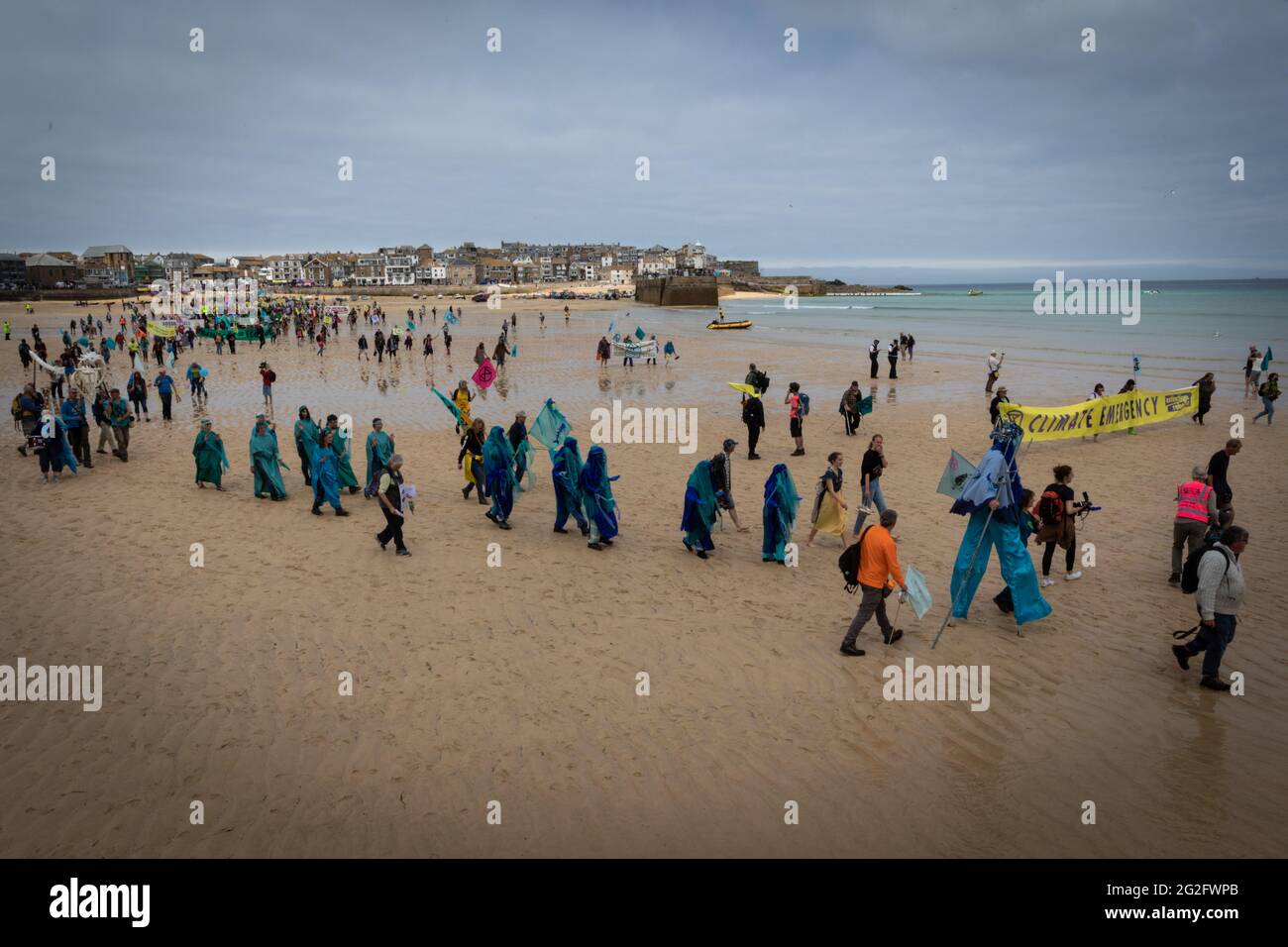 St Ives, UK. 11th June, 2021. Hundreds of protesters march across St Ives beach near where delegates are meeting for the 47th G7. Extinction Rebellion organised the demonstration to coincide with the G7-Summit. The event sees world leaders come together to discuss matters around climate change. Credit: Andy Barton/Alamy Live News Stock Photo