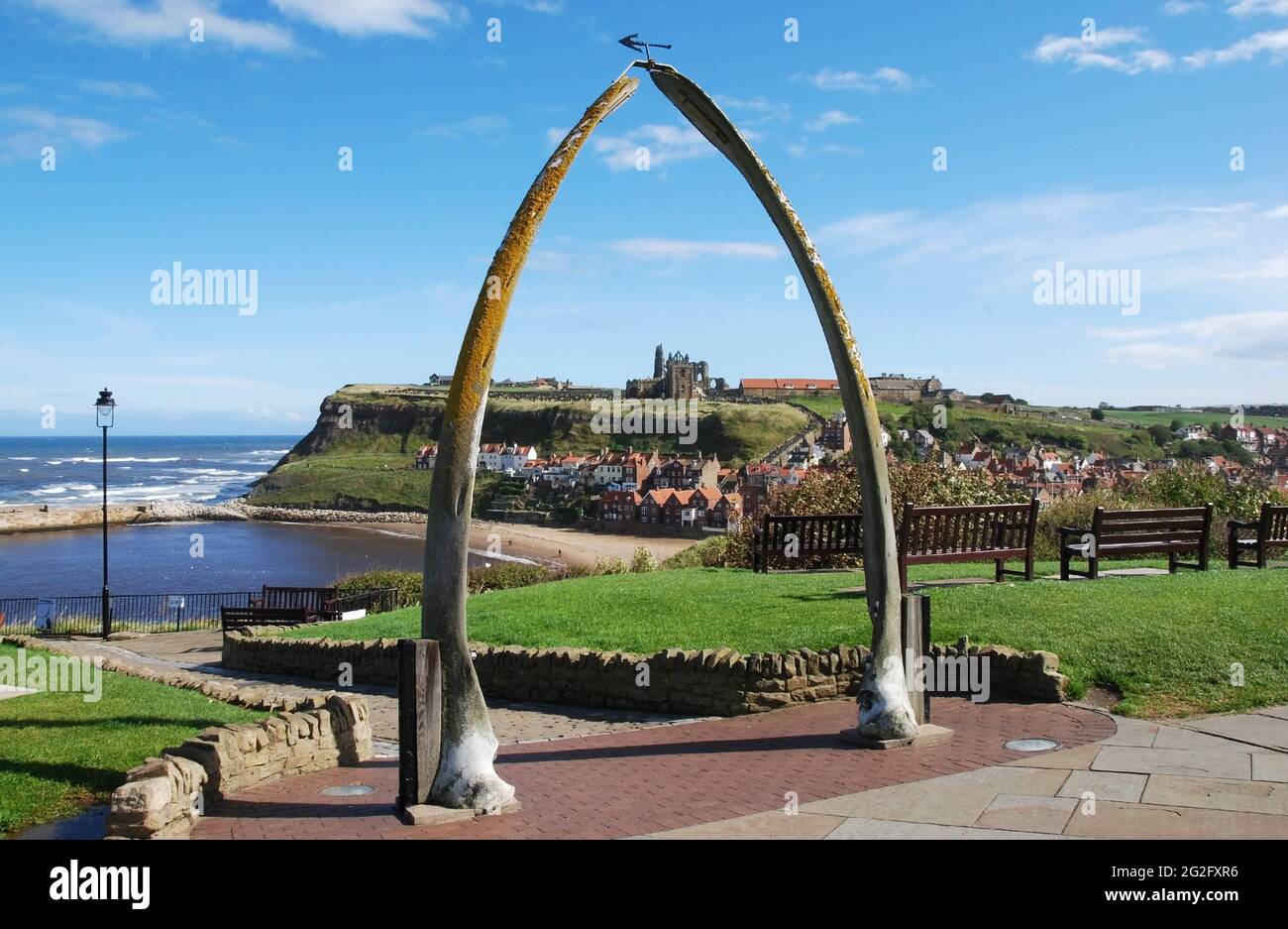 An arch made of whale jawbones at Whitby, North Yorkshire UK. The North Sea coast and Whitby Abbey are visible in the image. Stock Photo