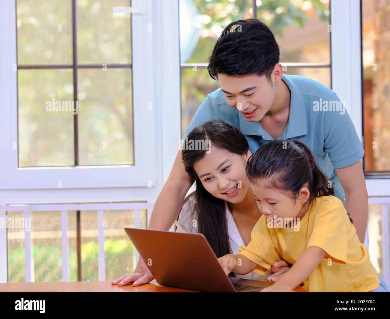 Happy family of three using laptop high quality photo Stock Photo