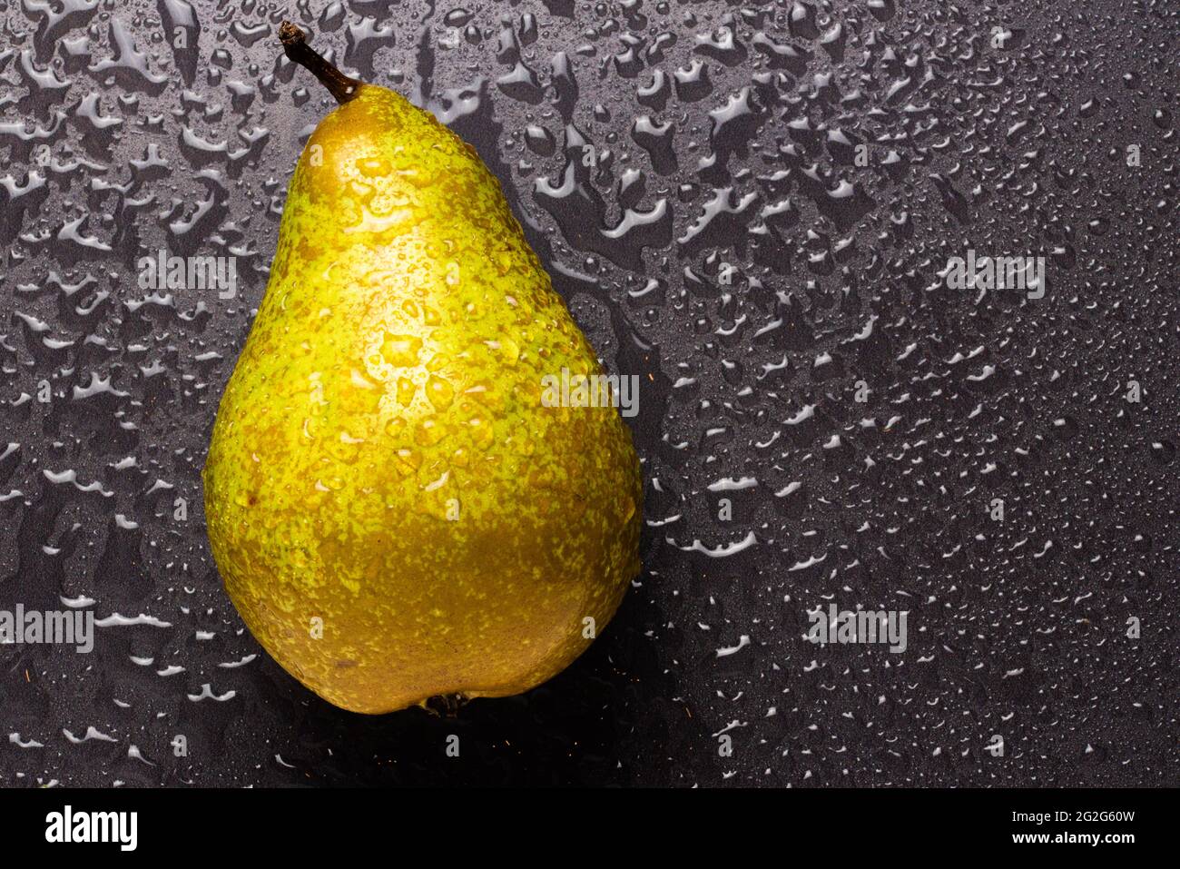 Pear fruit isolated on wet black background Stock Photo