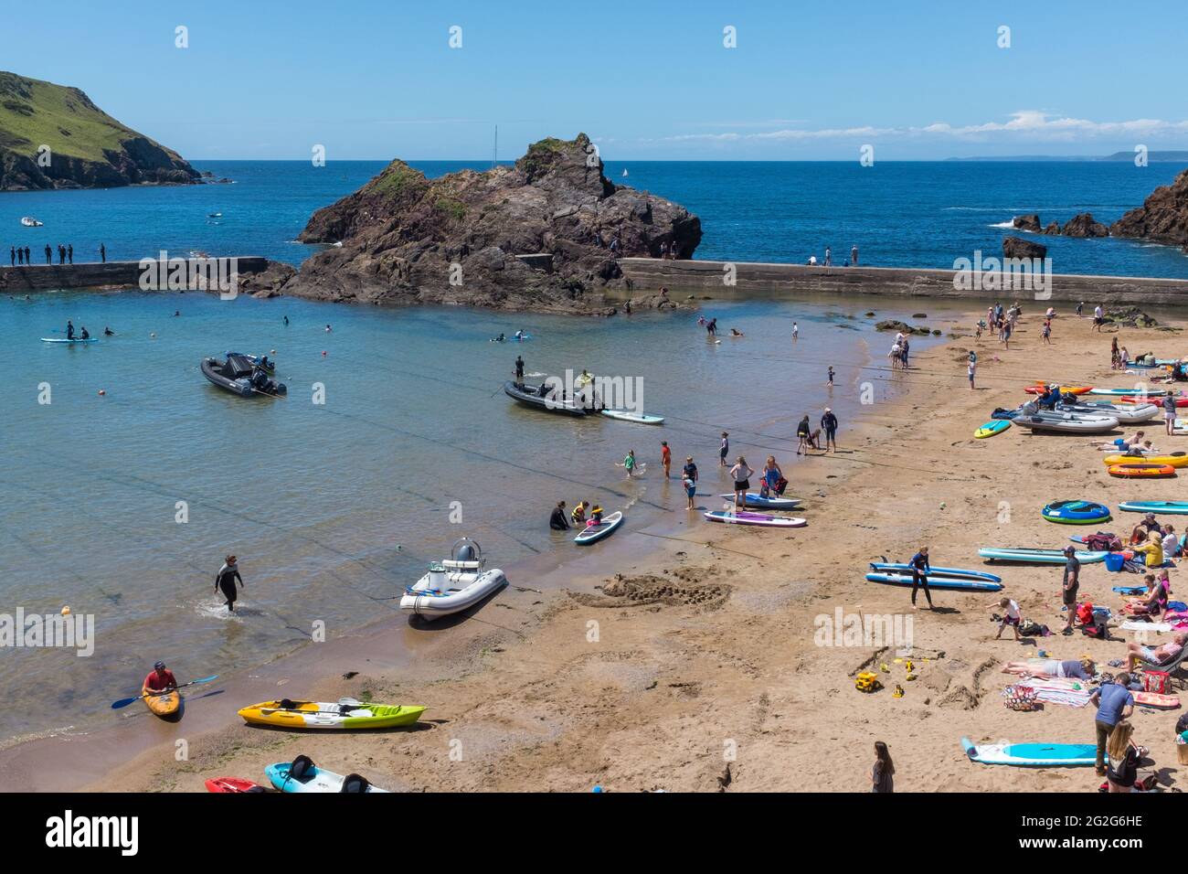 Holiday makers and boats on the beach at the holiday village of Hope Cove in the South Hams, Devon near Kingsbridge Stock Photo