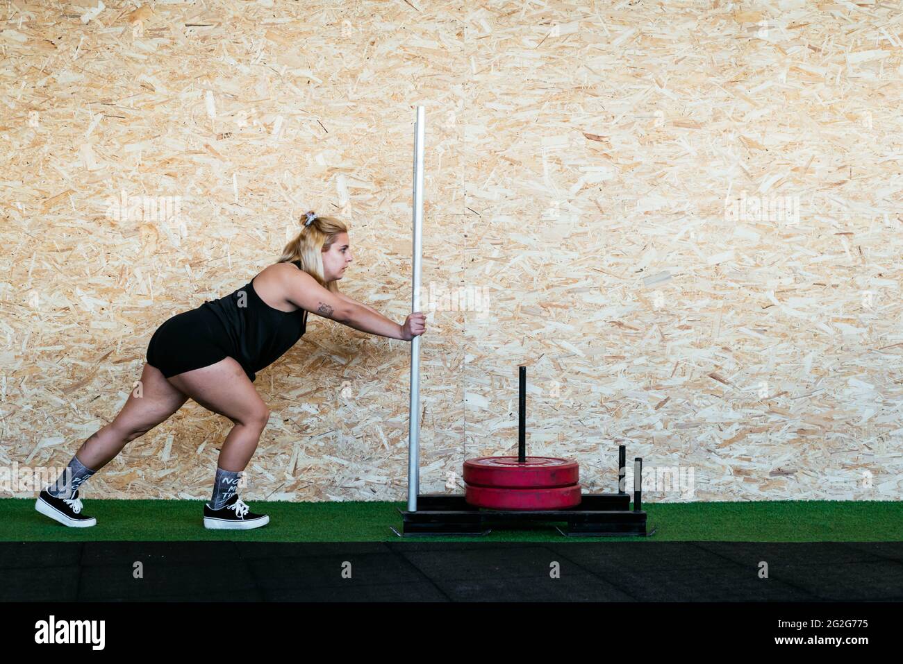Strong Woman Doing Sled Training At Gym Stock Photo