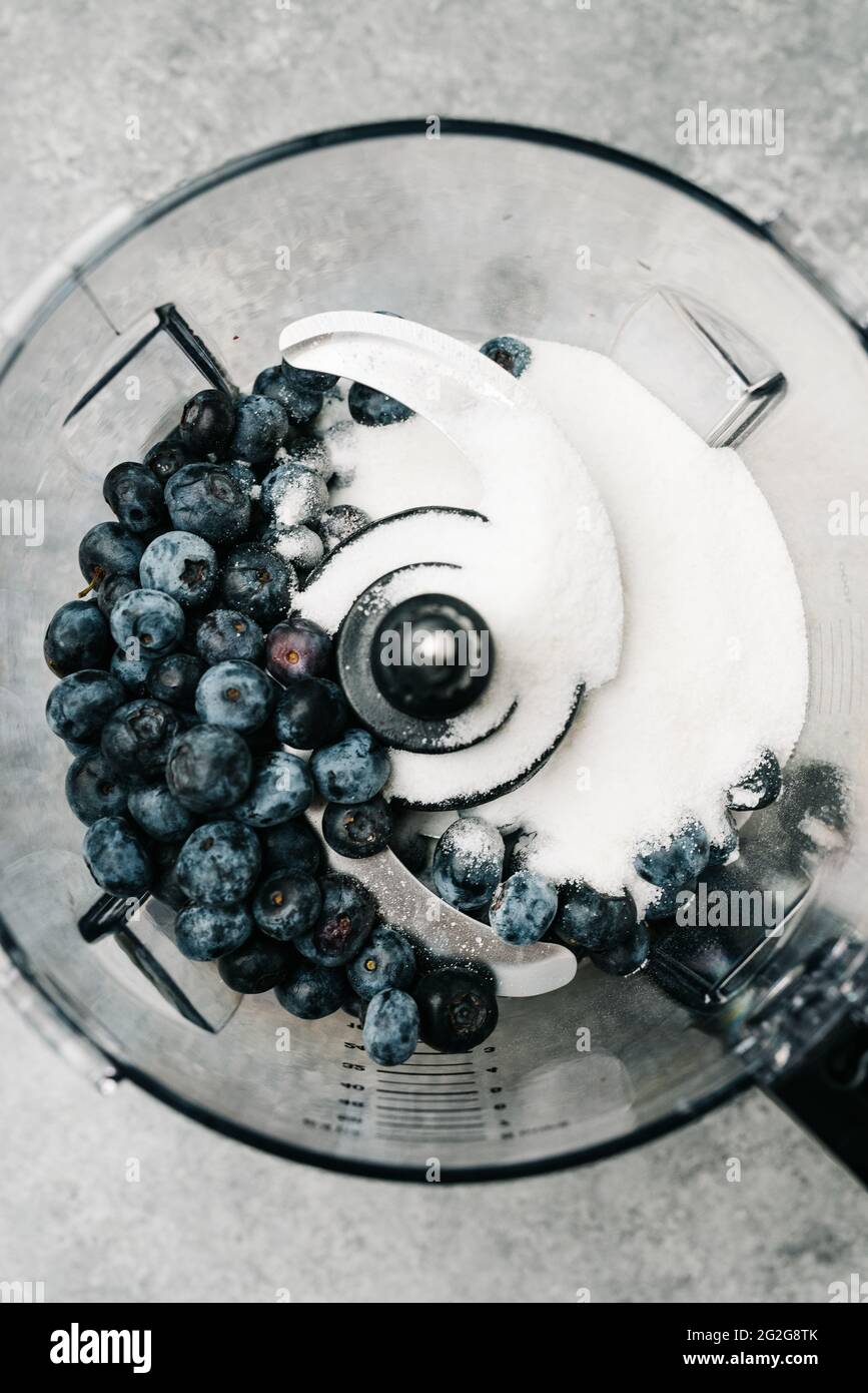 Overhead food processor with blueberries and sugar Stock Photo
