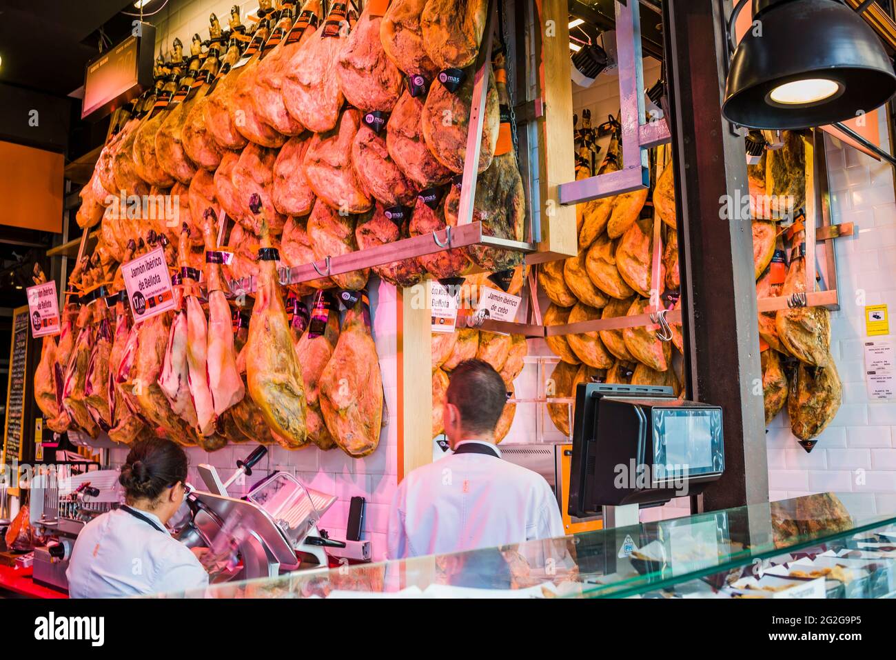 Spanish cured hams for sale in the Market of San Miguel. The Market of San Miguel, Mercado de San Miguel, is a covered market located in Madrid. Origi Stock Photo