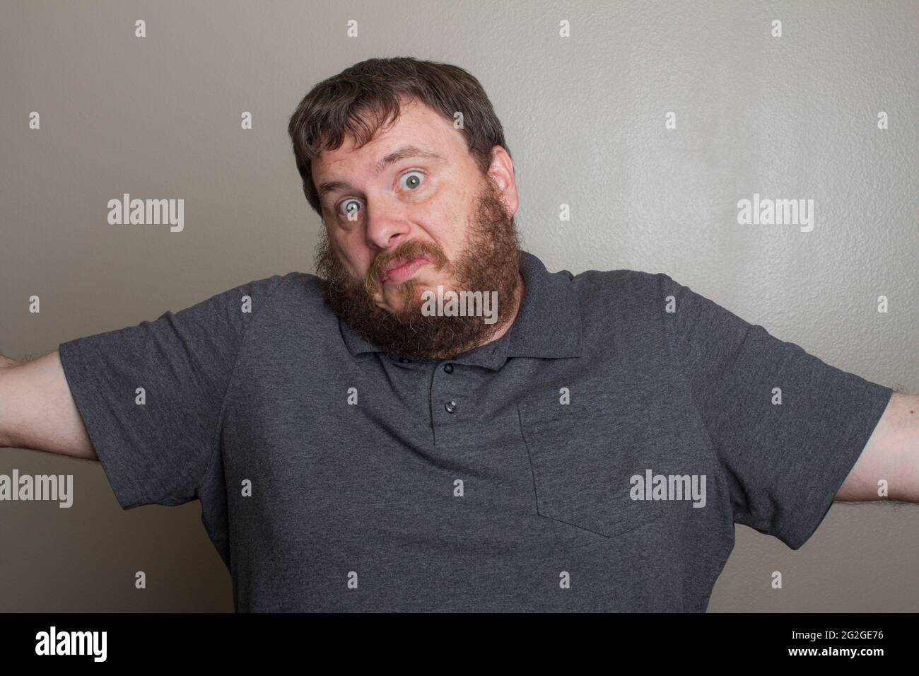 Man who could care less shrugging his shoulders Stock Photo