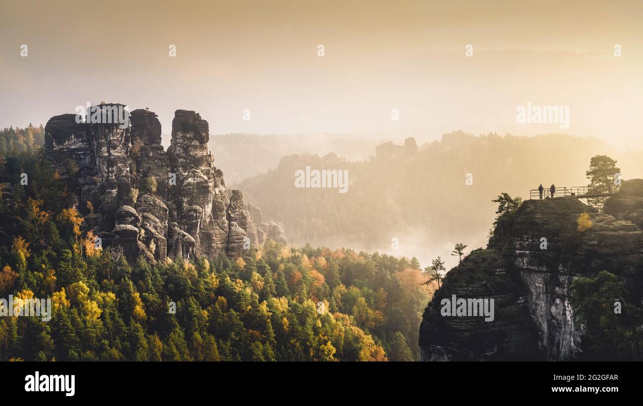 View from the Bastei at sunrise into the autumn-colored valley of the Elbe Sandstone Mountains. Stock Photo