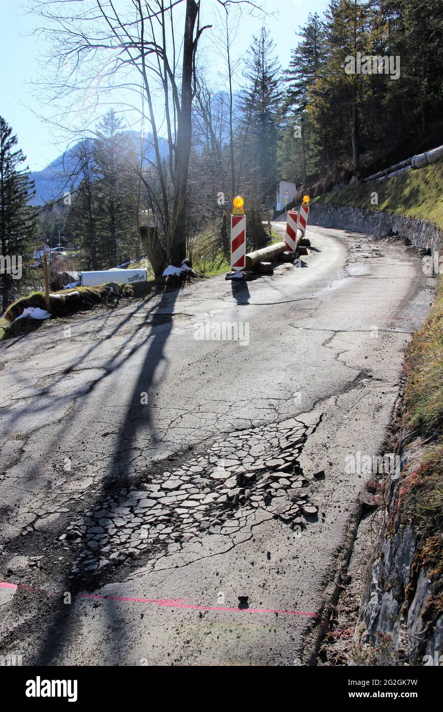 Construction site access, road damage in the tar pavement of a street near Mittenwald, sun, back light, construction site, hotel access, heavy transport, Europe, Germany, Bavaria, Upper Bavaria, Mittenwald, Werdenfelser Land, Isar valley Stock Photo