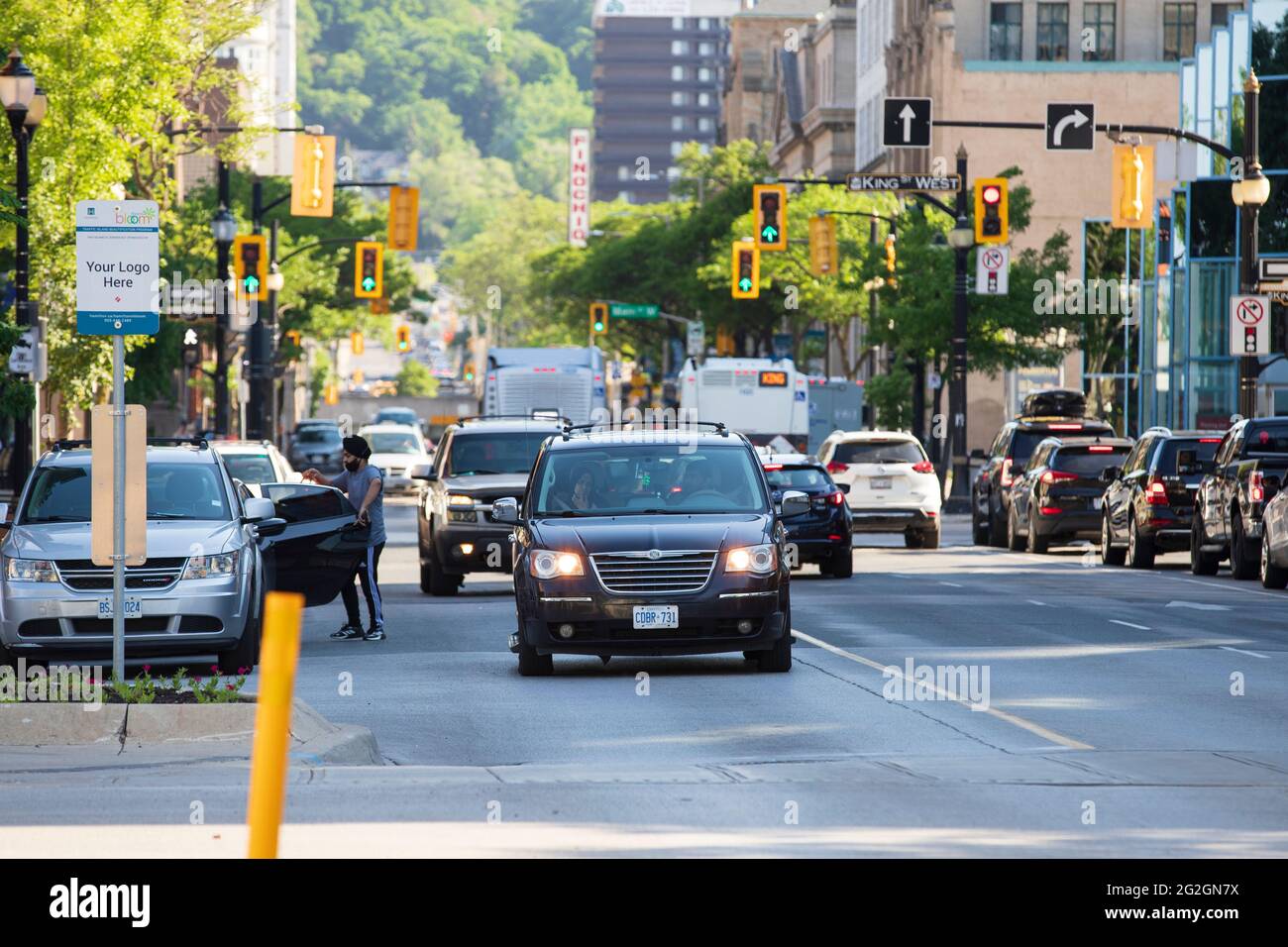 Cars driving across the intersection of James Street North and King Street West downtown Hamilton. Stock Photo