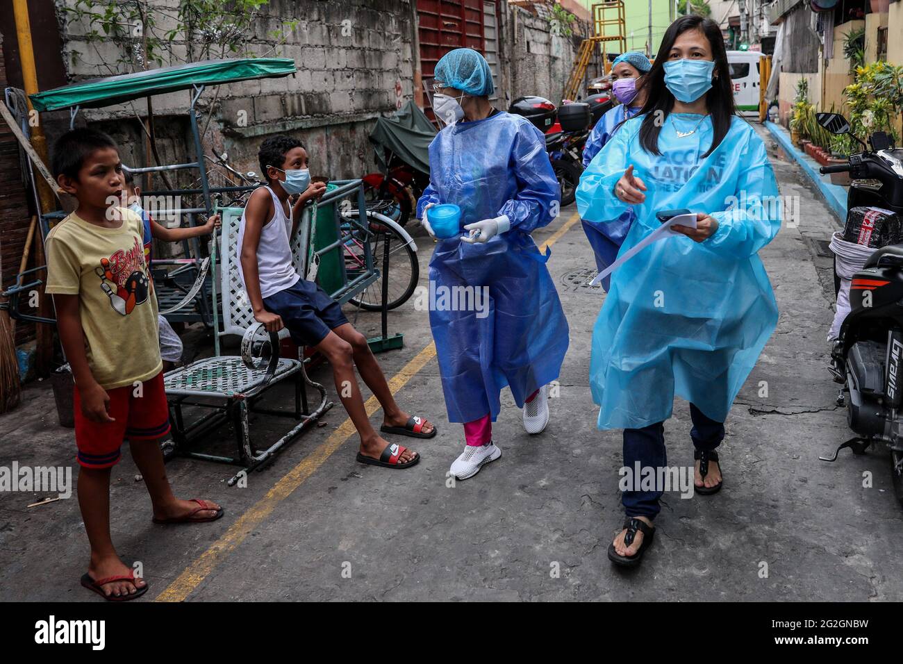 Medical workers prepare to inoculate a bedridden patient during a house vaccination program. The national government has expanded its COVID-19 vaccination rollout nationwide to those under the A4 category that covers essential workers, frontliners in national government offices, and uniformed personnel. Manila, Philippines. Stock Photo