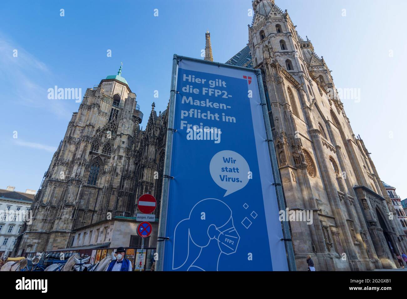 Wien, Vienna, Signage for FFP2 mask compulsory at cathedral Stephansdom (St. Stephen's Cathedral). Fiaker (horse cab). From Thursday, April 1st, an FFP2 mask is mandatory in the city center, including in certain outdoor areas, where many people recently met in a small space. in 01. Old Town, Wien, Austria Stock Photo