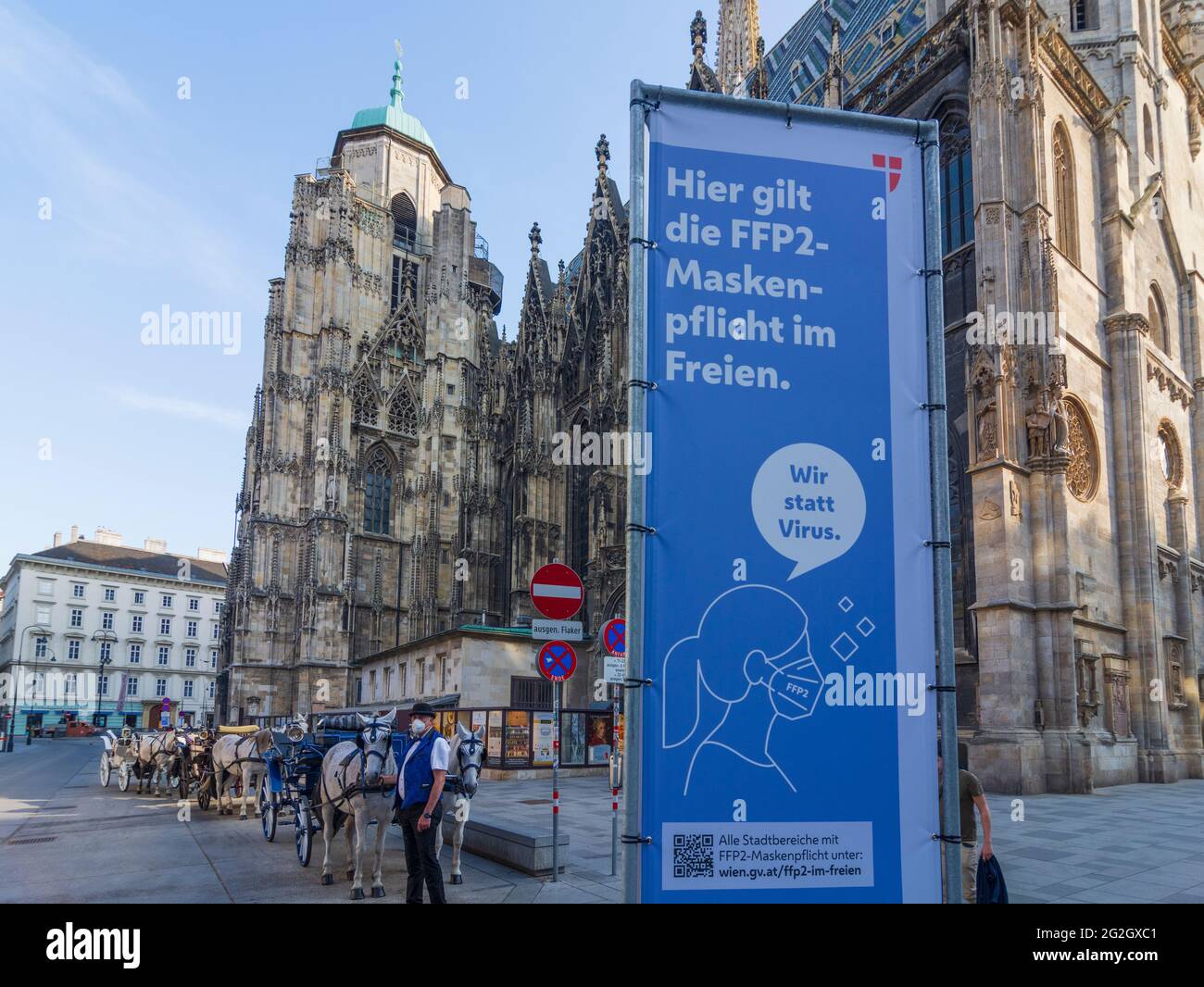 Wien, Vienna, Signage for FFP2 mask compulsory at cathedral Stephansdom (St. Stephen's Cathedral). Fiaker (horse cab). From Thursday, April 1st, an FFP2 mask is mandatory in the city center, including in certain outdoor areas, where many people recently met in a small space. in 01. Old Town, Wien, Austria Stock Photo