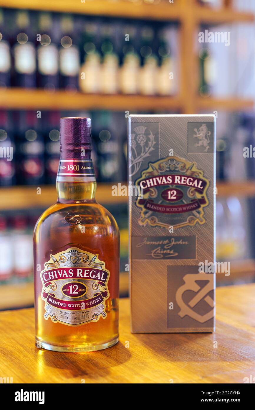 Whisky Chivas Regal bottle on wooden bar with out of focus pub background. Stock Photo