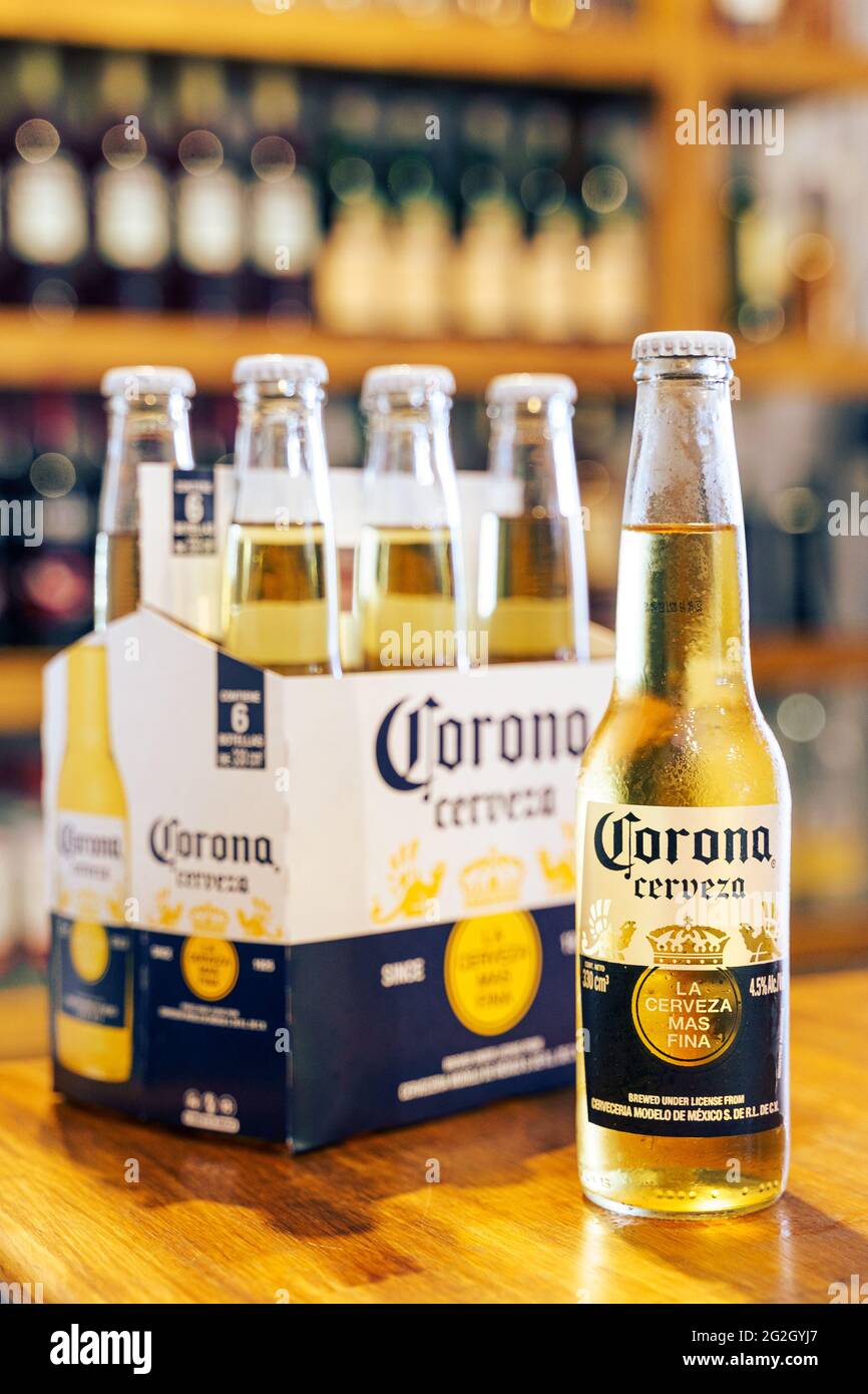 Corona Beer bottle on wooden bar with out of focus pub background. Stock Photo