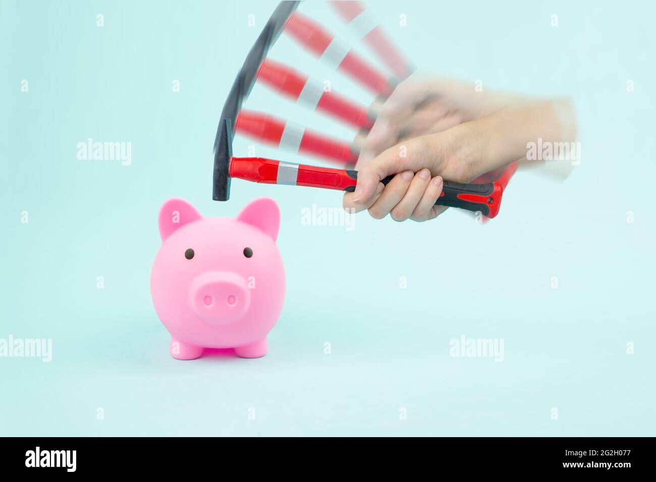 Hand hammer smashes piggy bank with savings. Concept of financial crisis Stock Photo