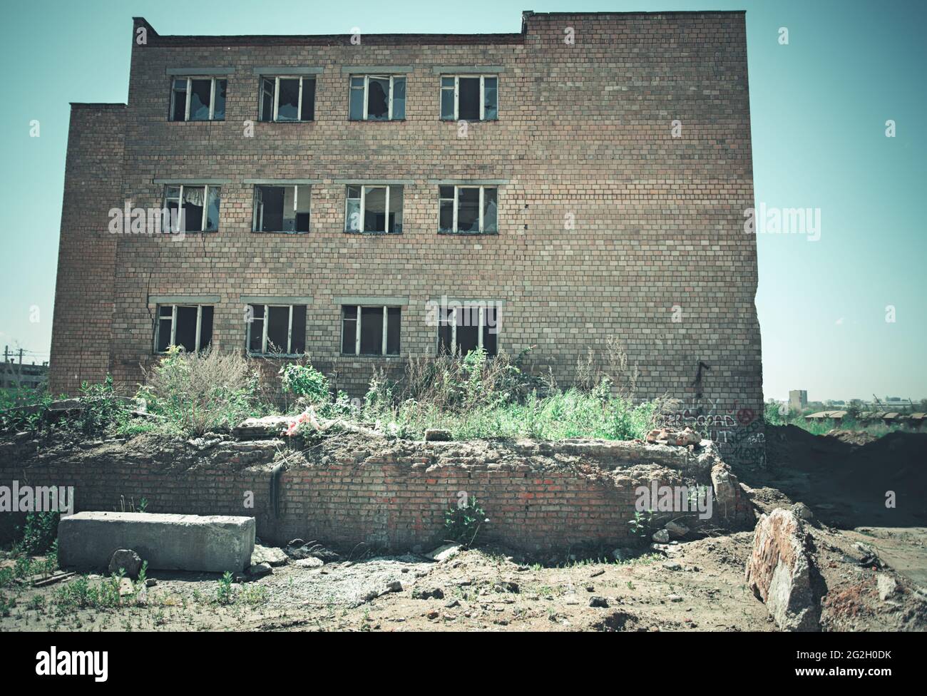Abandoned multi-story red brick factory building with broken glass ...