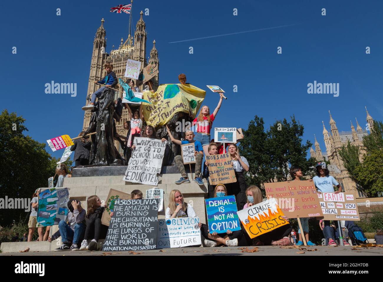 Children protesting against climate change on Auguste Rodin's sculpture 'The Burghers of Calais' in Victoria Tower Gardens, London. Stock Photo