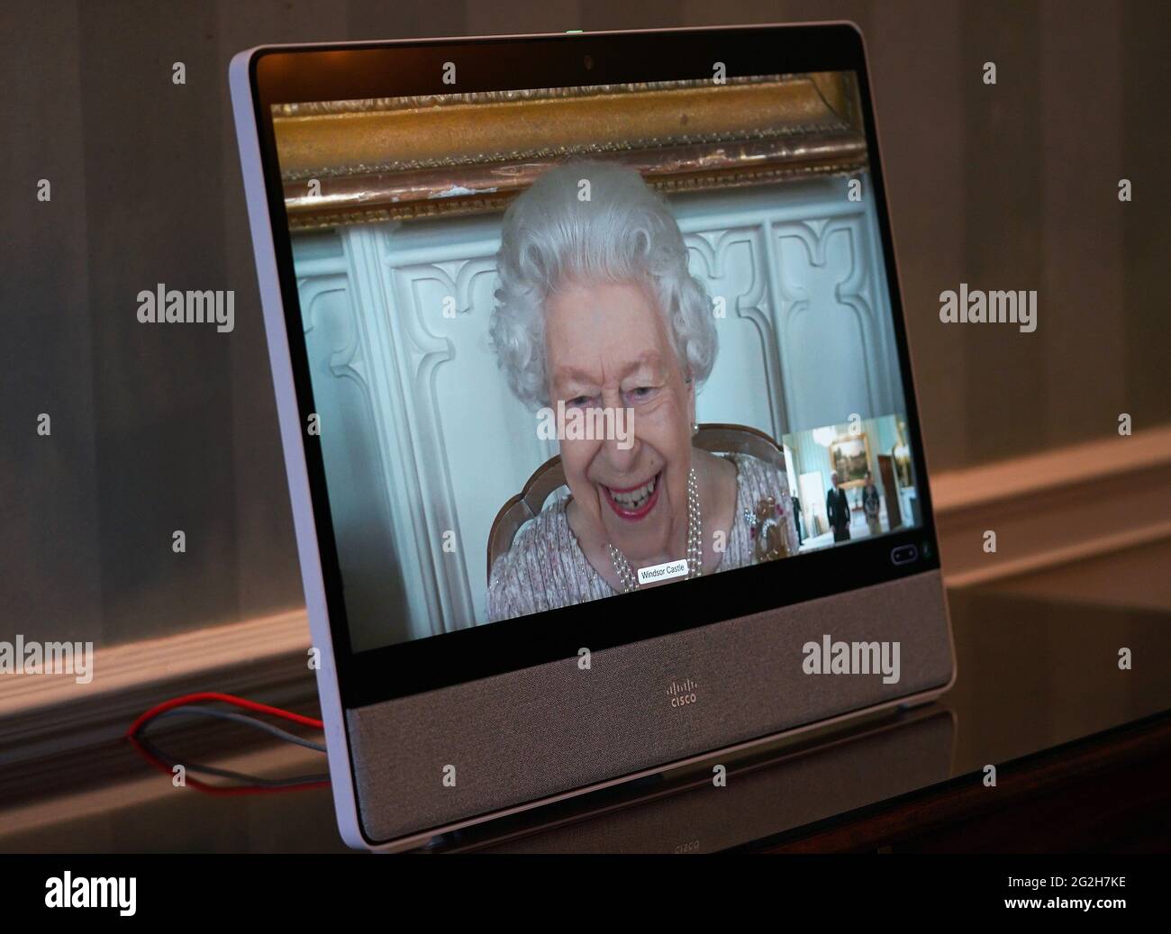 File photo dated 21/5/2021 of Queen Elizabeth II appearing on a screen by videolink from Windsor Castle, where she is in residence, during a virtual audience to receive His Excellency Lim Tuan Kuan, the High Commissioner for the Republic of Singapore, and his wife Patricia Teh, at Buckingham Palace, London. After months of the Windsors carrying out virtual royal engagements, working from home and relying on online catch ups to see family, the Queen has honoured her head of IT operations for services to the monarchy. Issue date: Friday June 11, 2021. Stock Photo