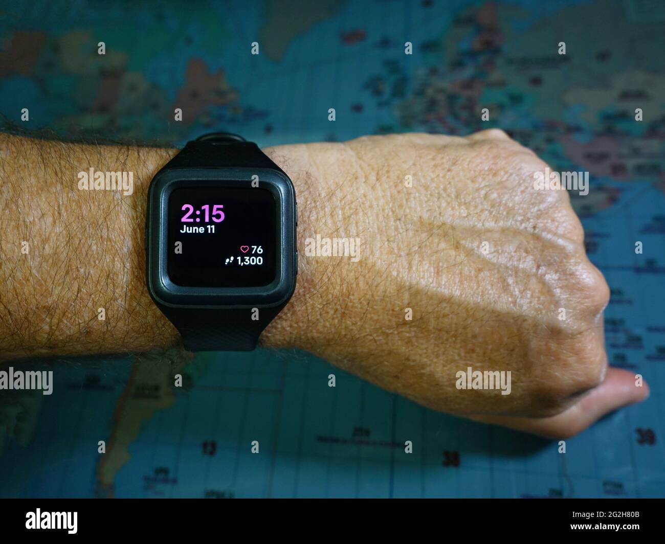 Fitness watch on mans forearm showing date, time, heart rate and step