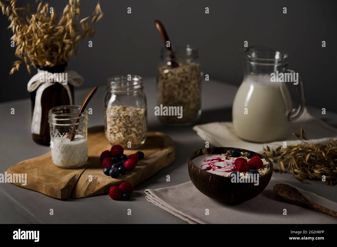 Oat milk, bowl, oat ears, oatmeal, spoon, jug Stock Photo