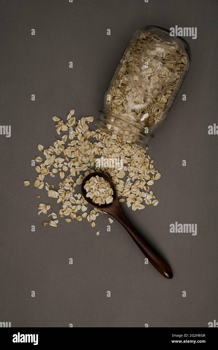 Oatmeal, scattered, mason jar, lying, fallen over, spoon, top view Stock Photo