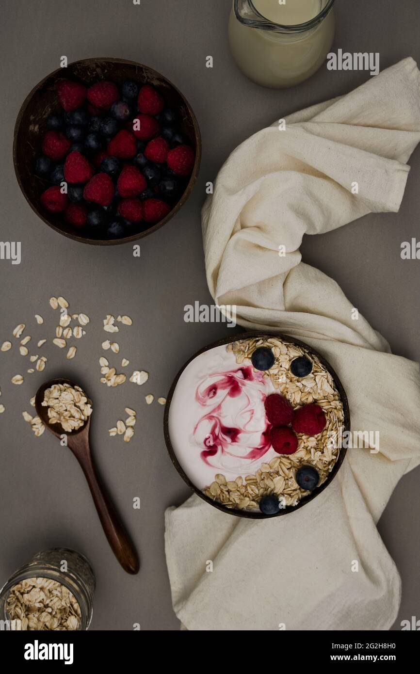 Oat milk, top view, bowl, berries, spoon, strainer Stock Photo