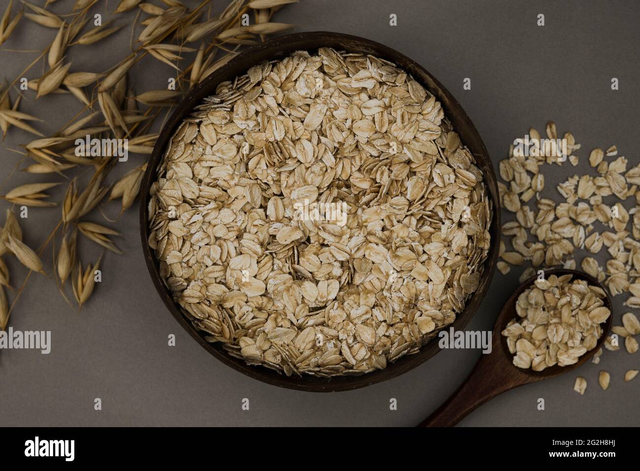 Oatmeal, bowl, ear of wheat, spoon, top view Stock Photo