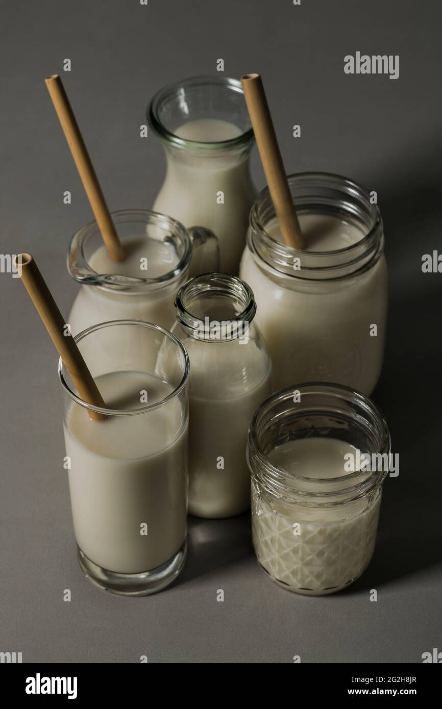 Oat milk, drinking straws, glass, carafe, mason jar, milk bottle Stock Photo