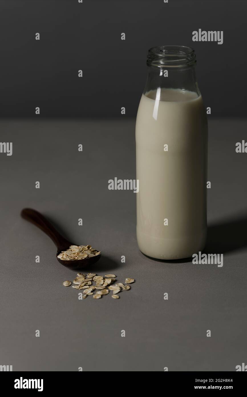 Oat milk, milk bottle, spoon, oatmeal Stock Photo