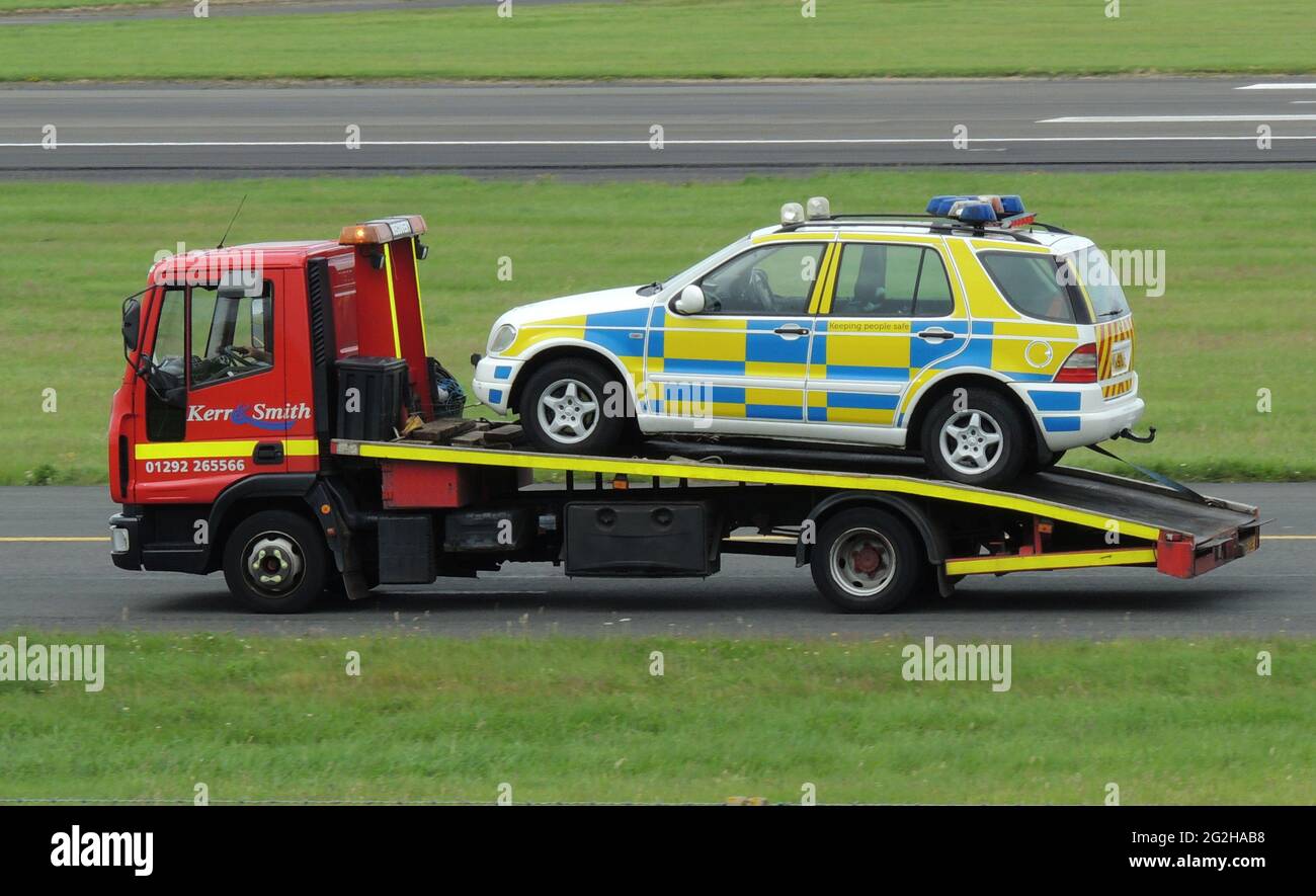 After suffering a breakdown at Prestwick International Airport, a Mercedes-Benz M-class police car is taken away on a Kerr & Smith recovery vehicle. Stock Photo