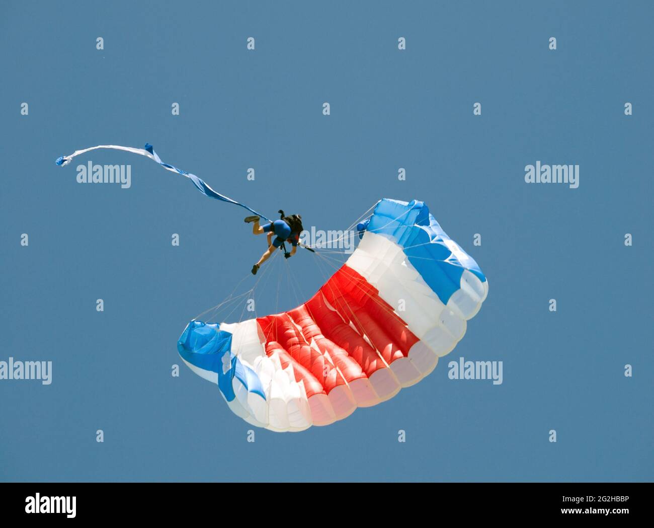 Skydiver hanging on parachute in air Stock Photo