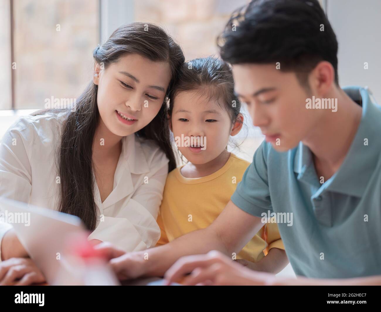 Happy family of three using laptop high quality photo Stock Photo