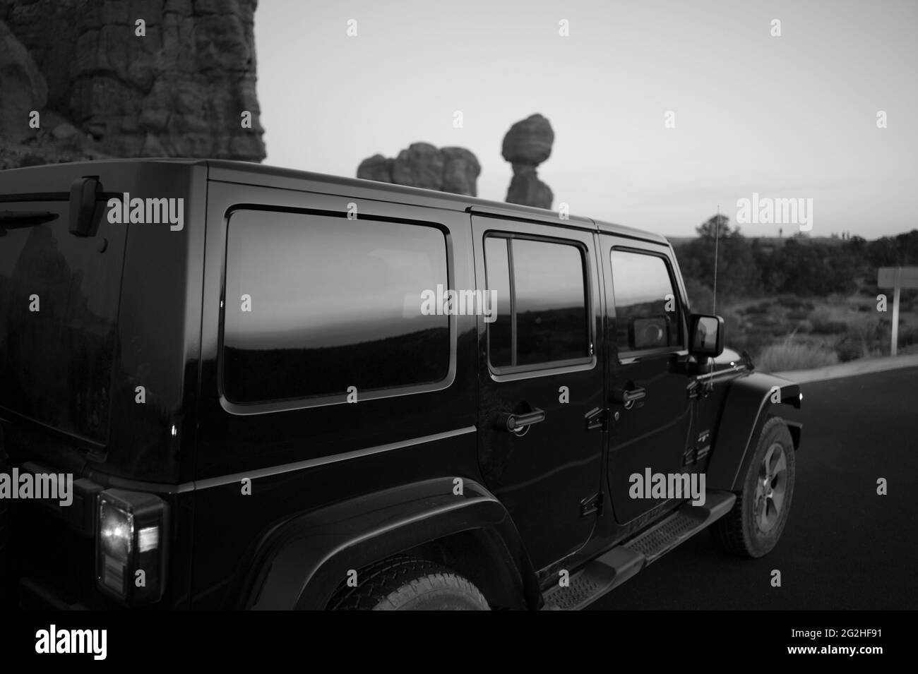 Wrangler Jeep at the parking spot at the Balanced Rock - a massive rock resting on a narrow pillar in Arches National Park, near Moab in Utah, USA Stock Photo