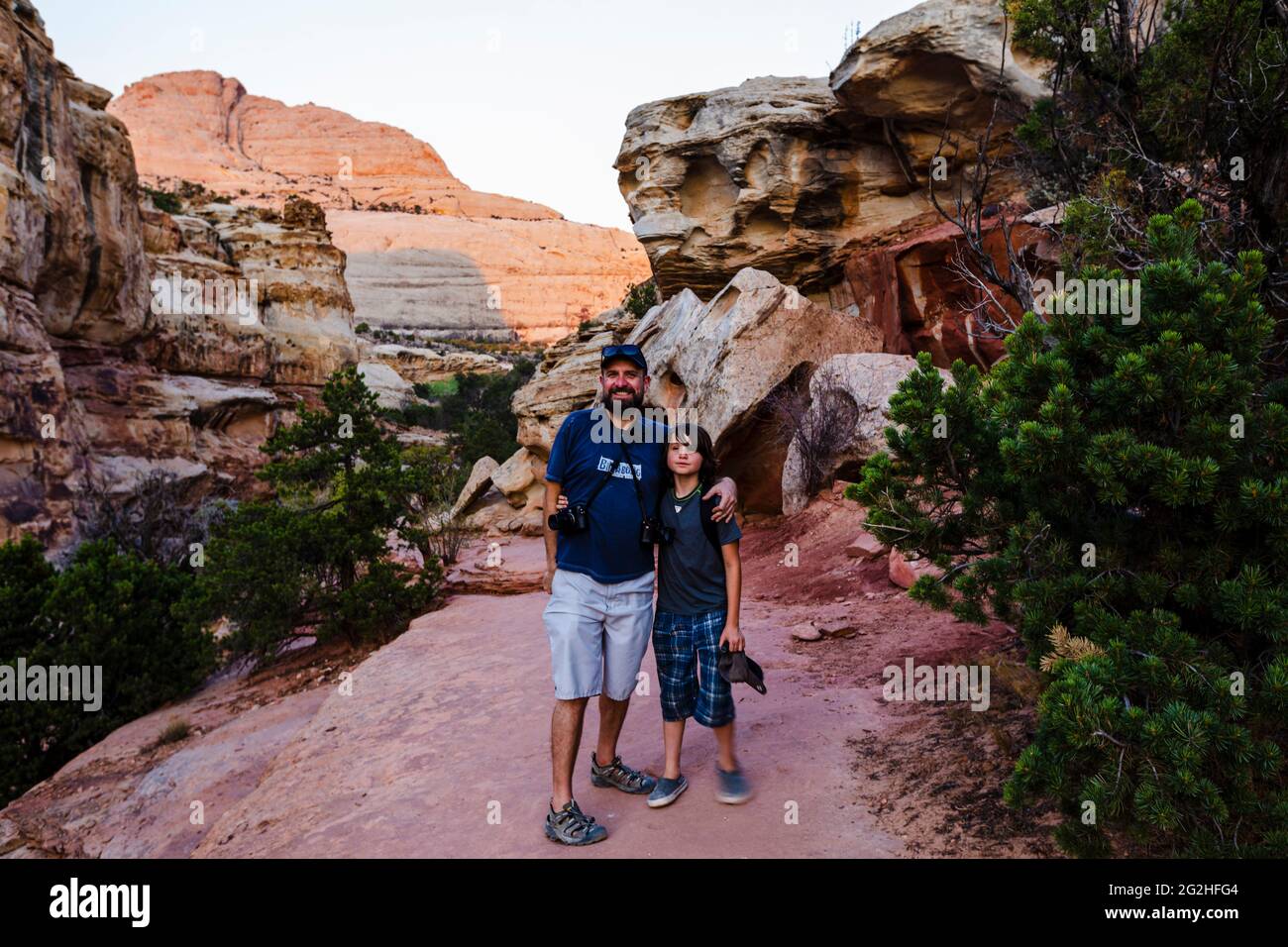 Father and son hiking on the Hickman Bridge Trail Head inside the Capitol Reef National Park near Torrey, Utah, USA. Stock Photo